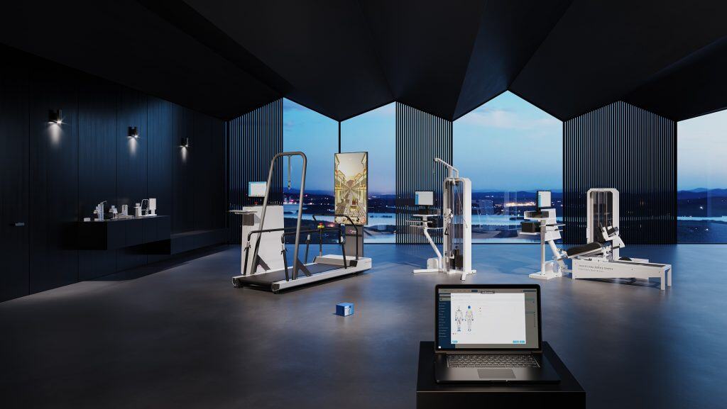 Un gimnasio moderno con aparatos de fitness blancos y elegantes, una pantalla digital y un ordenador portátil en un espacio oscuro y abierto con vistas panorámicas a través de grandes ventanales al atardecer.